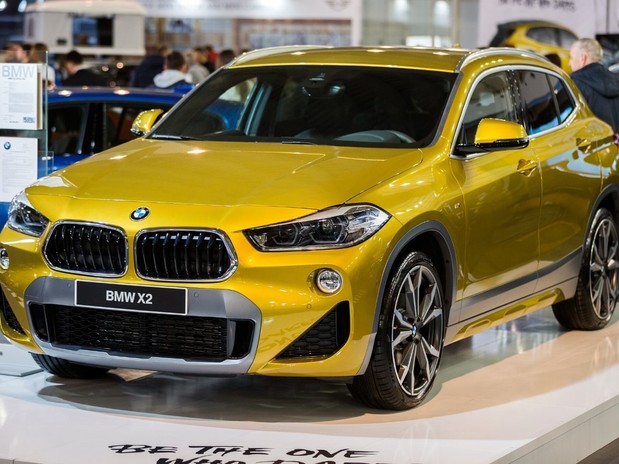 The BMW X2 in an off yellow colour, front three quarter view at a Belgrade car show